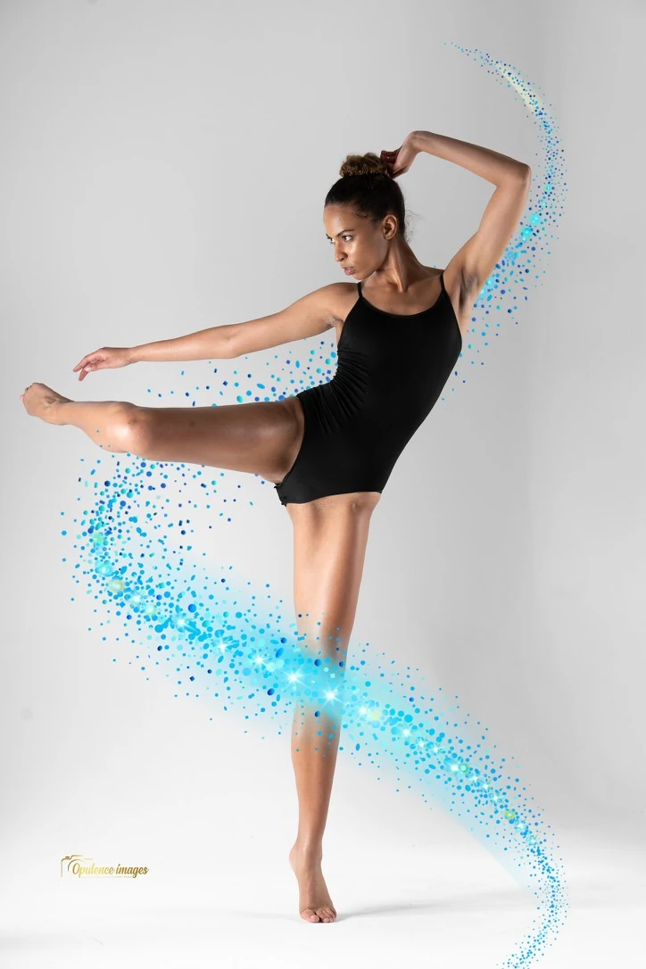 Claire Ofotokun (COFO) balancing in a black dance outfit with a blue particle effect sweeping around her.