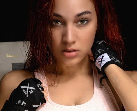 Close-up portrait of a woman wearing boxing gloves