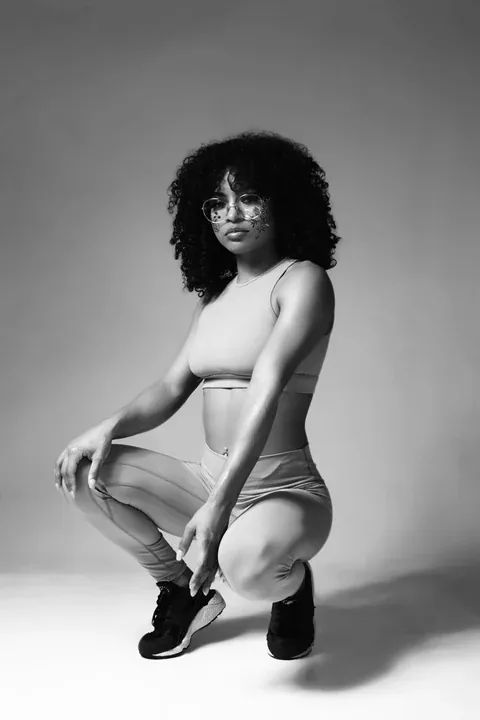 Black and white studio portrait of a crouching athlete