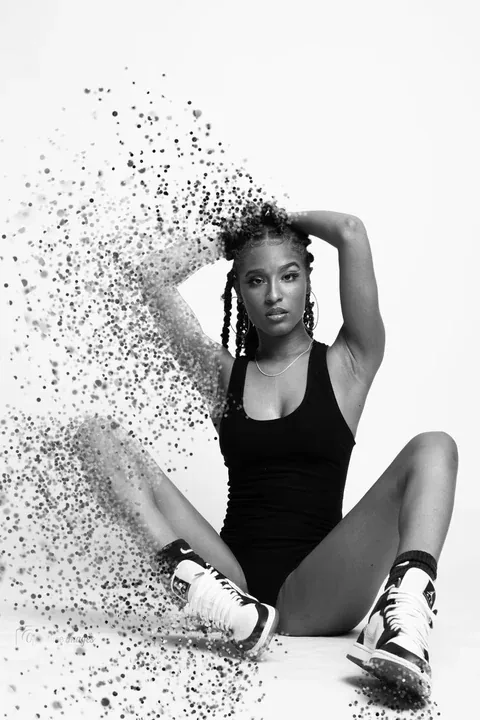 Black and white portrait dissolving into particles