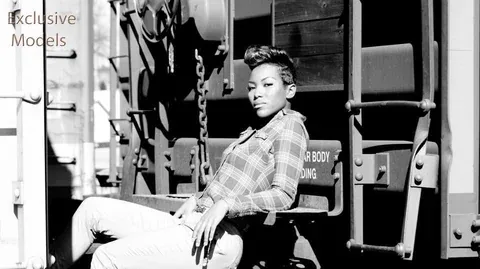 Black and white widescreen portrait against a railcar, with Exclusive Models lettering